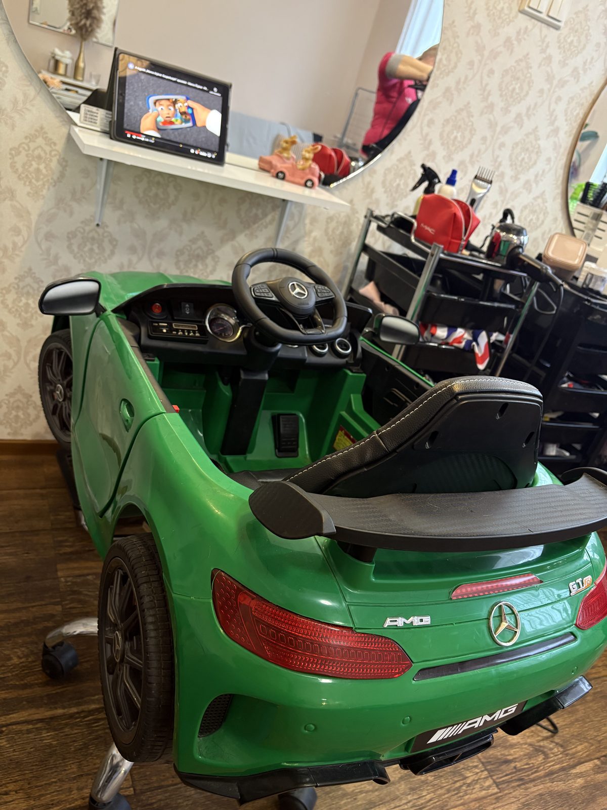 Zöld Mercedes AMG formájú gyerek fodrászszék a szalonban